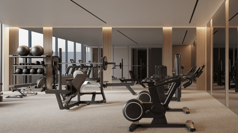 Une salle de sport moderne dotée d'une variété d'équipements, notamment des tapis roulants, des poids et des supports, située dans un appartement de Dubaï avec des panneaux en bois et un éclairage d'ambiance.