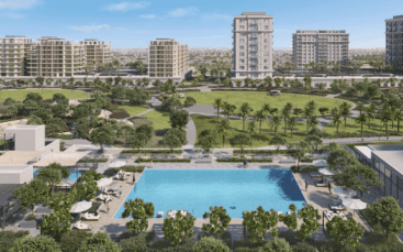 Eine luxuriöse Wohnanlage in Dubai mit einem großen Pool, der von Liegestühlen und Sonnenschirmen umgeben ist, grünen Gärten und mehreren mittelhohen Apartmentgebäuden im Hintergrund. Ein gepflegter Park mit Wanderwegen und Palmen ist jenseits des Pools zu sehen. Perfekt für alle, die nach gehobenen Immobilienoptionen in Dubai suchen.
