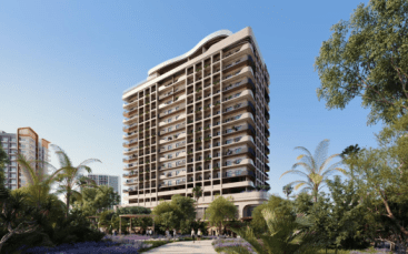 Un moderno grattacielo residenziale circondato da giardini lussureggianti, con persone che camminano sui vialetti e palme che ondeggiano in primo piano sotto un cielo azzurro e limpido, disponibile tramite una delle principali agenzie immobiliari di Dubai.