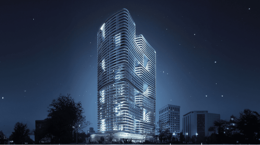 Un gratte-ciel futuriste à Dubaï illuminé la nuit avec un design présentant des façades incurvées et superposées sur un ciel étoilé, entouré d'autres structures urbaines.