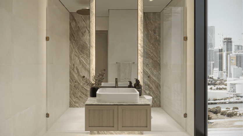 Une salle de bains moderne dans une villa à Dubaï comprenant un lavabo rectangulaire sur une vasque en bois, avec des murs en marbre et une grande fenêtre offrant une vue sur la ville.