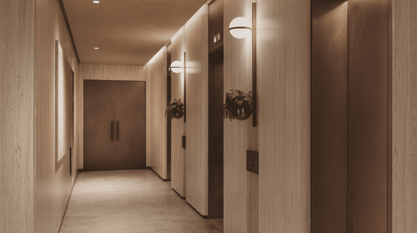 Couloir d'hôtel moderne à Dubaï avec un éclairage chaleureux, des murs texturés et une décoration symétrique avec des plantes près des portes d'ascenseur.