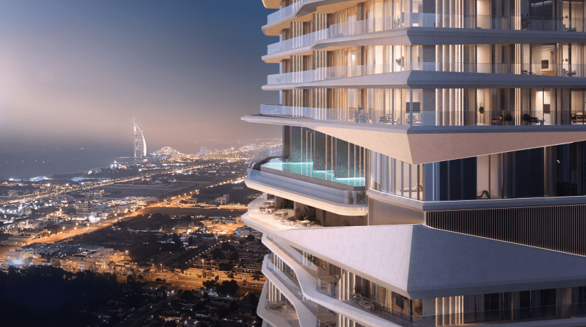 Un immeuble moderne de grande hauteur doté de balcons décalés uniques, certains dotés de piscines, surplombe un paysage urbain au crépuscule. Les lumières de la ville scintillent et une tour emblématique au bord de l'eau est visible au loin sous un ciel crépusculaire.