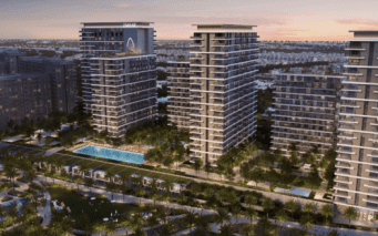 Une vue aérienne de luxueux immeubles résidentiels de grande hauteur au crépuscule à Dubaï, avec une verdure luxuriante, une piscine et des intérieurs illuminés, sur fond de toits de la ville.