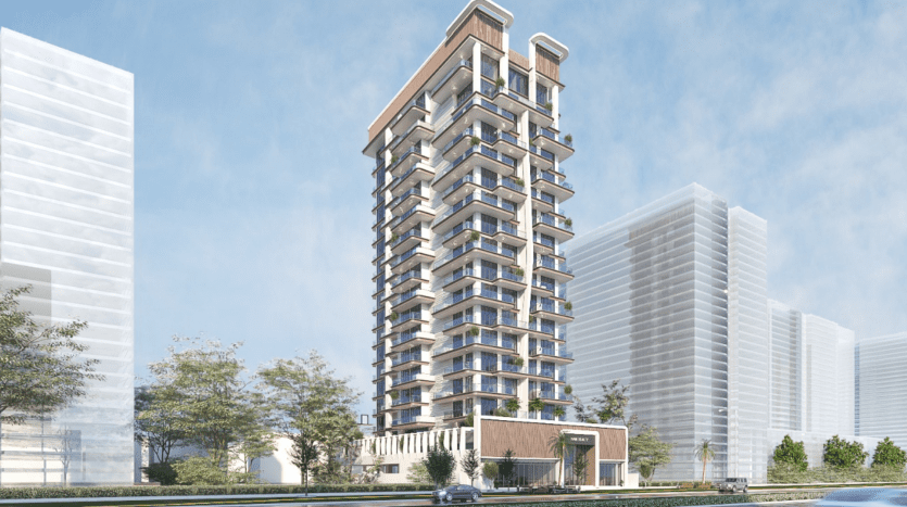 Un immeuble résidentiel moderne de grande hauteur, Primero Residences Al Furjan, doté de nombreux balcons, se dresse sur un ciel partiellement nuageux. La zone environnante comprend des bâtiments de grande hauteur supplémentaires, des arbres et un véhicule qui passe sur la route devant la structure.