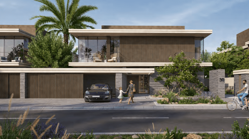 Une scène de rue résidentielle moderne à Dubaï montrant une villa contemporaine avec de grandes fenêtres et un toit plat, entourée d'une verdure luxuriante. Une femme passe devant la maison tandis qu’une autre personne passe devant elle à vélo.