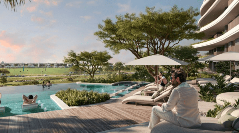 Un cadre moderne et luxueux au bord de la piscine avec vue sur le golf de Verdes. Les gens se prélassent sur des transats sous les parasols, tandis que d'autres profitent de la piscine à débordement. Des arbres et de la verdure entourent la zone et une personne en tenue blanche est assise près du bord de la piscine.