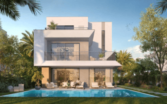 Une maison blanche moderne de deux étages dotée de grandes fenêtres et de balcons est nichée le long d'une ruelle calme, entourée d'une verdure luxuriante. Dans la cour, il y a une piscine rectangulaire avec des chaises longues et des plantes autour du patio. Le ciel est clair et bleu.