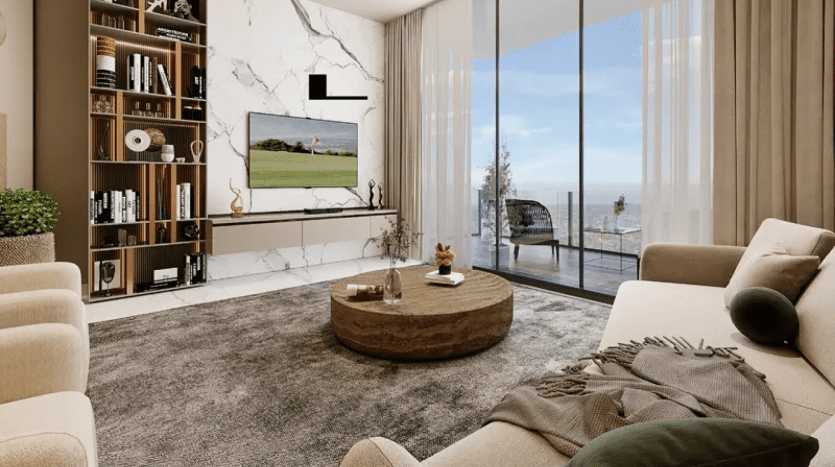 Salon moderne avec baies vitrées offrant une vue sur l'océan. Les caractéristiques comprennent un canapé beige clair, une table basse ronde en bois, un tapis gris, un mur de télévision en marbre et des étagères avec des objets de décoration. Palette de couleurs neutres avec des accents verts et gris.