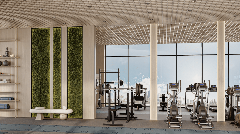 Une salle de sport moderne dispose de baies vitrées avec vue, de machines elliptiques alignées, d'un banc d'haltérophilie avec haltères et de jardins verticaux verdoyants sur le mur. Les tapis de yoga et les accessoires sont soigneusement disposés sur le côté gauche de la pièce.
