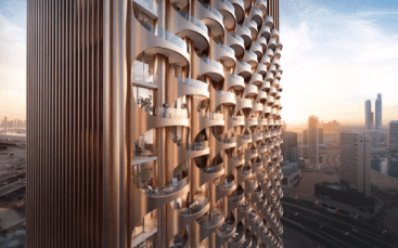 Una vista ravvicinata di One Residences, un moderno grattacielo con un'esclusiva facciata curva realizzata con elementi metallici. Il design crea uno schema di balconi semicircolari, mentre il paesaggio urbano con i grattacieli e il fiume è visibile sullo sfondo al tramonto.