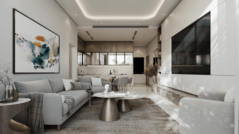 Le salon moderne du Skyhills 2 est doté d'un canapé gris, d'œuvres d'art abstraites et d'un plaid rayé. Une grande télévision est fixée au mur, tandis que la salle à manger et la cuisine ouverte en arrière-plan présentent des accents de bois et un éclairage suspendu. La lumière naturelle inonde les fenêtres, mettant en valeur le design élégant.