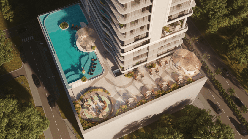 Vue aérienne d'Allura Residences, un immeuble moderne à plusieurs étages doté d'un espace de loisirs sur le toit. Le toit comprend une grande piscine, des espaces de détente avec transats et des espaces verts paysagers. Des routes adjacentes et des arbres luxuriants entourent le bâtiment, offrant un environnement serein.