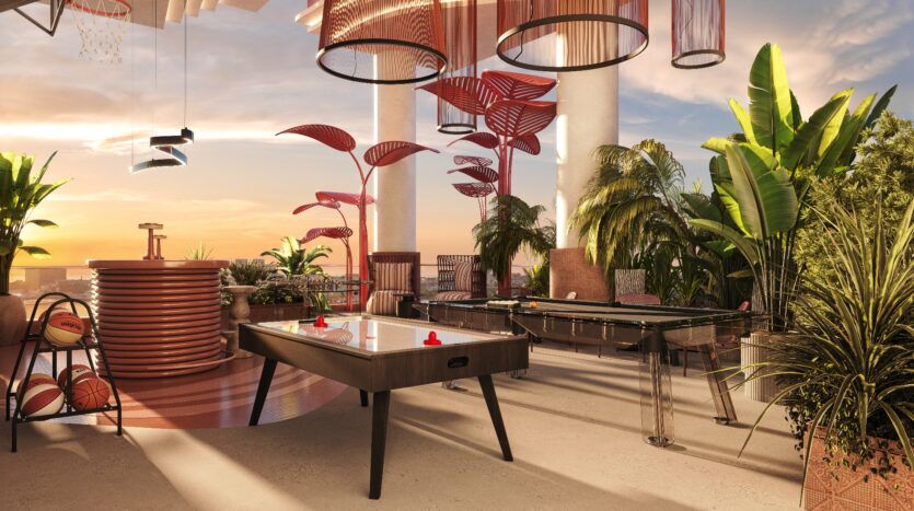 L'espace de loisirs moderne d'Allura Residences comprend une table de air hockey, un baby-foot et un panier de basket. L'espace présente des décorations végétales vibrantes, un éclairage suspendu élégant et une vue sur le coucher de soleil en arrière-plan, créant une atmosphère relaxante et amusante.