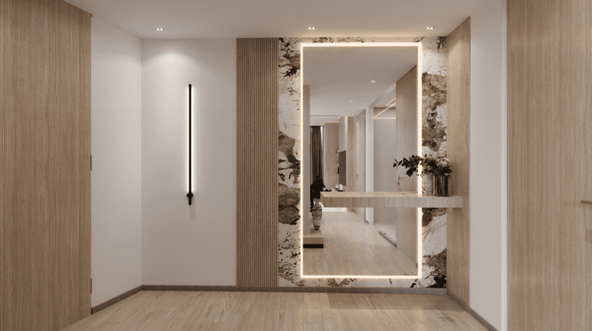 Un couloir moderne du Binghatti Royale est doté d'un grand miroir rétroéclairé et d'une petite étagère avec des fleurs. Le design met en valeur les boiseries et les accents de marbre sur les murs, complétés par un parquet en bois clair. Une bande lumineuse verticale orne le mur de gauche.