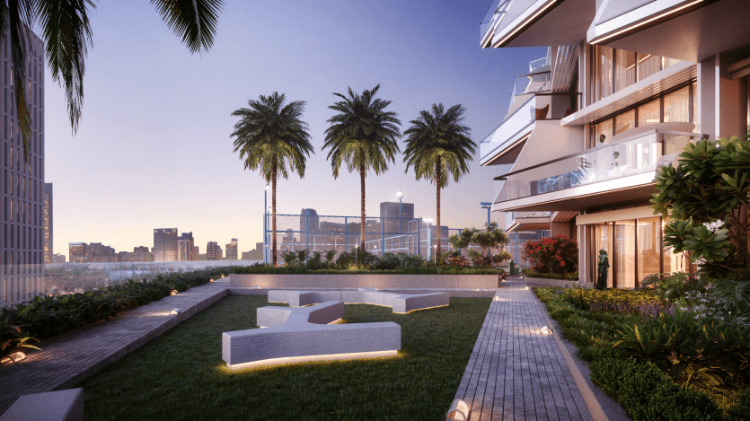 Un jardin en terrasse serein au crépuscule avec vue sur les toits de la ville, notamment le magnifique Binghatti Royale. Le jardin présente une végétation luxuriante, de grands palmiers et des structures modernes avec un éclairage élégant. Les bâtiments adjacents sont visibles et le ciel passe du crépuscule à la nuit.
