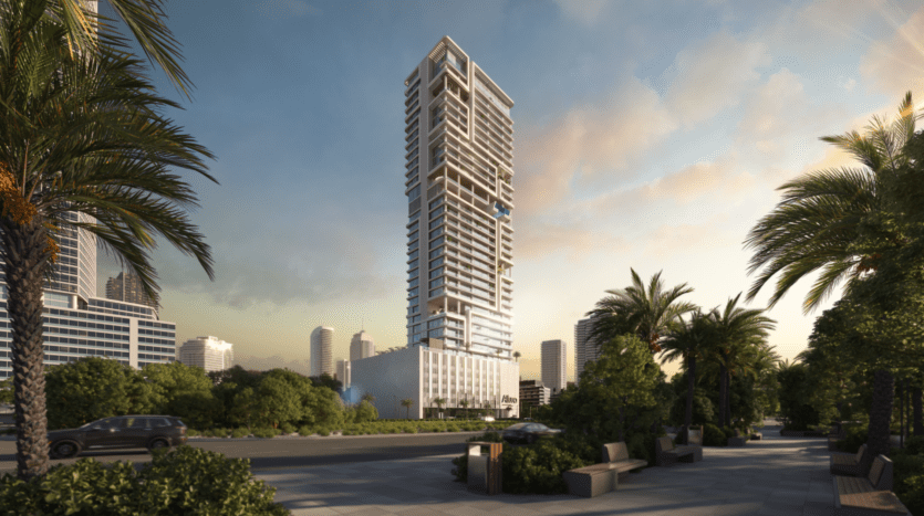 Un gratte-ciel moderne et élevé conçu par Allura Citi Developers se dresse au milieu d'un paysage urbain au coucher du soleil. Des palmiers et des espaces verts paysagers bordent le premier plan, tandis que quelques nuages parsèment le ciel. Les bâtiments à proximité suggèrent un cadre urbain.