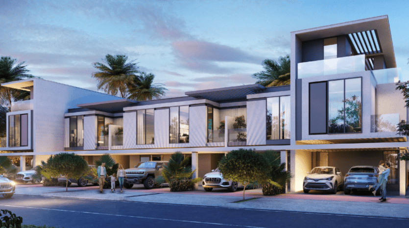 Complexe de maisons de ville moderne au crépuscule, avec de grandes fenêtres, plusieurs niveaux et une conception architecturale épurée rappelant une villa de Sun City Damac. Des palmiers sont disséminés un peu partout et les voitures sont garées dans des abris pour voitures désignés, avec un éclairage doux créant une ambiance accueillante.