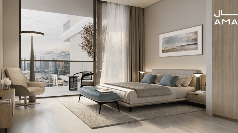 Chambre moderne avec un grand lit, une décoration bleu sarcelle et beige et une chaise moelleuse. Une porte vitrée s'ouvre sur un balcon donnant sur les toits de la ville avec Amaal 8 ornant la vue. Des œuvres d'art ornent les murs tandis qu'une plante en pot ajoute de la vie à l'espace, le tout éclairé par une lumière naturelle et chaleureuse.