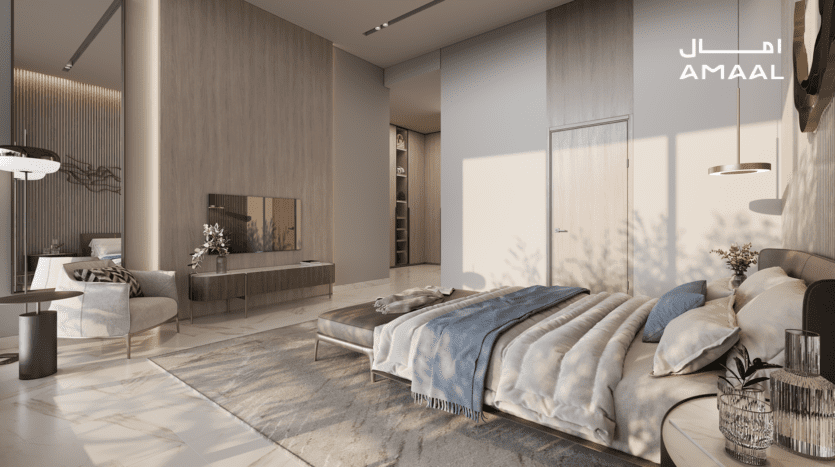 Une chambre luxueuse au design moderne dispose d'un grand lit orné de coussins et d'un plaid bleu clair. On y trouve un fauteuil confortable, une télévision à écran plat sur un meuble Amaal 8 et des éléments de décoration élégants. La lumière du soleil entre à flots, mettant en valeur les tons chauds.