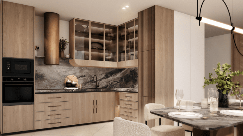 La cuisine et la salle à manger modernes du W Residences sont dotées d'armoires en bois, d'un dosseret en marbre, d'un four double et d'un comptoir noir. La table à manger est élégamment dressée avec des assiettes, des verres et une plante verte centrale sous une élégante suspension.