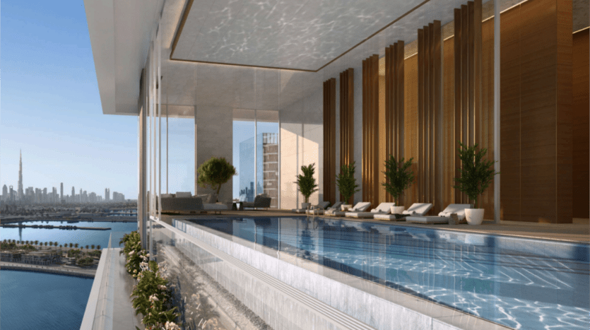 Une luxueuse piscine intérieure avec de grandes fenêtres donnant sur les toits de la ville, avec la tour Saria au loin. La piscine est entourée de chaises longues et d'une végétation luxuriante, le tout élégamment bordé d'une barrière en verre.