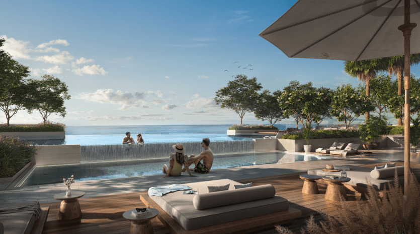Une piscine à débordement en bord de mer avec des gens qui se détendent dans l'eau. Un couple se prélasse au bord de la piscine, profitant de la vue sereine sur l'océan de Saria. Des transats et un grand parasol sont installés sur la terrasse en bois. Une végétation luxuriante enveloppe la zone sous un ciel bleu clair.