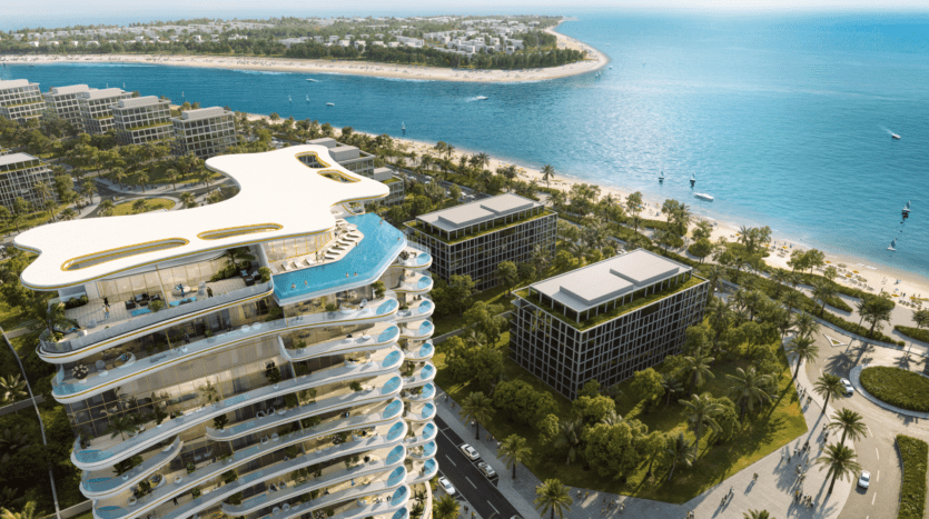Vue aérienne du luxueux complexe hôtelier Beach Walk Grand avec sa piscine sur le toit unique surplombant l'océan. Les palmiers et la verdure environnants rehaussent le paysage époustouflant. Le littoral se courbe gracieusement, avec des eaux bleues claires et de petits bateaux dispersés tout autour.