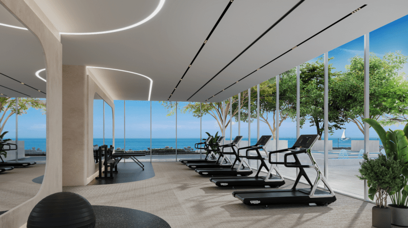 La salle de sport moderne de LIV Maritime est dotée de tapis roulants faisant face à de grandes fenêtres offrant une vue panoramique sur l'océan. Avec un design minimaliste, des murs de couleur claire et des plantes décoratives, l'espace offre une atmosphère aérée et rafraîchissante.