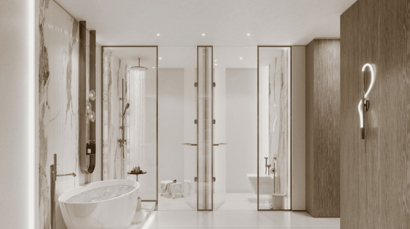 La salle de bains moderne évoque l'ambiance sereine de Sunset Bay, avec une grande baignoire autoportante remplie d'eau, une douche à effet pluie derrière des portes vitrées et d'élégants murs en marbre. Un éclairage chaleureux rehausse son décor minimaliste, avec une serviette et des articles de toilette soigneusement disposés sur une étagère murale.