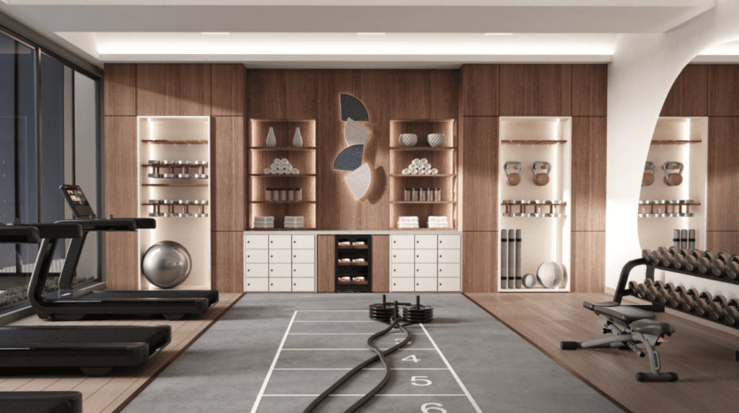 L'intérieur moderne de la salle de sport Hillgate comprend des étagères en bois exposant des serviettes, des kettlebells et des œuvres d'art décoratives. L'équipement d'entraînement comprend des tapis roulants, un banc, des poids et des cordes de combat. De grandes fenêtres baignent l'espace de lumière naturelle tandis qu'une piste au sol numérotée ajoute de la fonctionnalité.