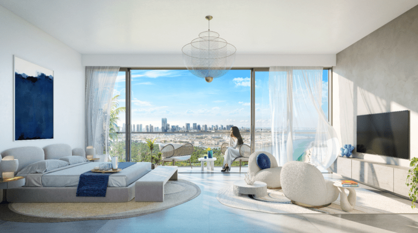 Une chambre moderne et spacieuse avec des fenêtres panoramiques révèle un paysage urbain et un rivage océanique. Elle dispose d'un grand lit, d'un coin salon confortable et d'une télévision à écran plat. Une femme est assise sur une chaise, profitant de la vue tandis que la lumière du soleil inonde la pièce.