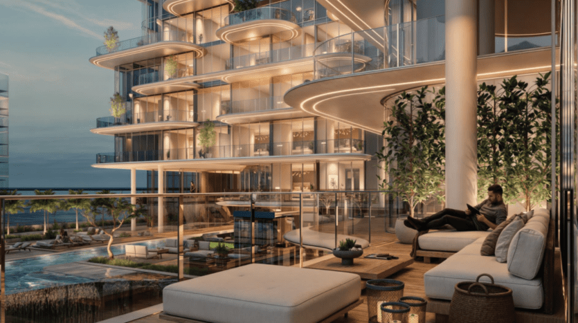 Une luxueuse terrasse moderne de Cotier House met en scène un homme se relaxant sur un canapé, entouré de balustrades en verre et de plantes luxuriantes. Le cadre comprend un éclairage élégant, une piscine et une vue imprenable sur l'océan, dégageant une ambiance tranquille et sophistiquée.