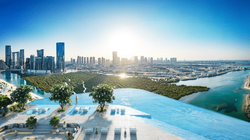 Une superbe piscine à débordement au Rivage surplombe l'horizon urbain au coucher du soleil. Une végétation luxuriante est nichée entre des gratte-ciels modernes et des voies navigables sinueuses, créant un contraste serein. Les sièges au bord de la piscine offrent un endroit luxueux pour admirer la vue panoramique.