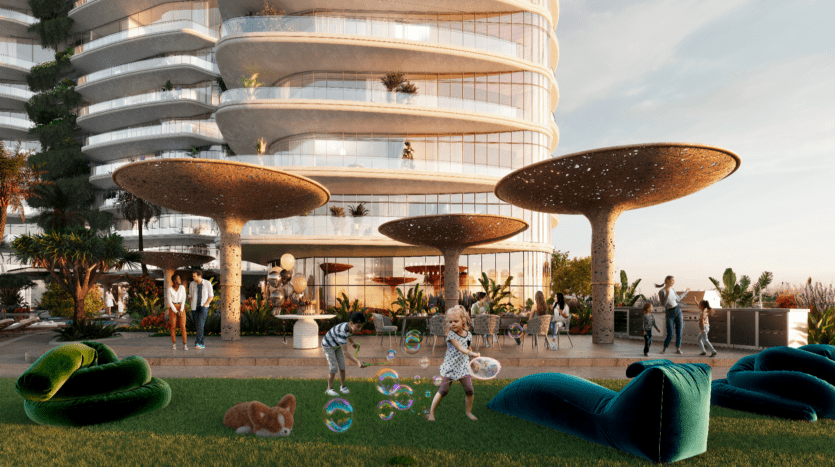 Sur la terrasse du Rivage, à proximité de bâtiments modernes aux formes arrondies, des enfants jouent avec des bulles. De grandes structures uniques en forme de champignon offrent de l'ombre. Des adultes discutent en arrière-plan et un chien se détend sur l'herbe. La scène est animée et se déroule à la lumière du jour.