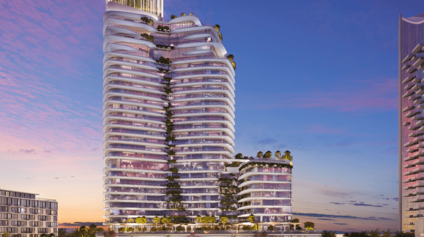 Un gratte-ciel moderne à plusieurs étages nommé Rivage présente une architecture incurvée distinctive, une végétation luxuriante sur les balcons et des fenêtres illuminées. Sur fond de ciel de coucher de soleil vibrant, il se dresse élégamment avec d'autres bâtiments visibles à proximité.