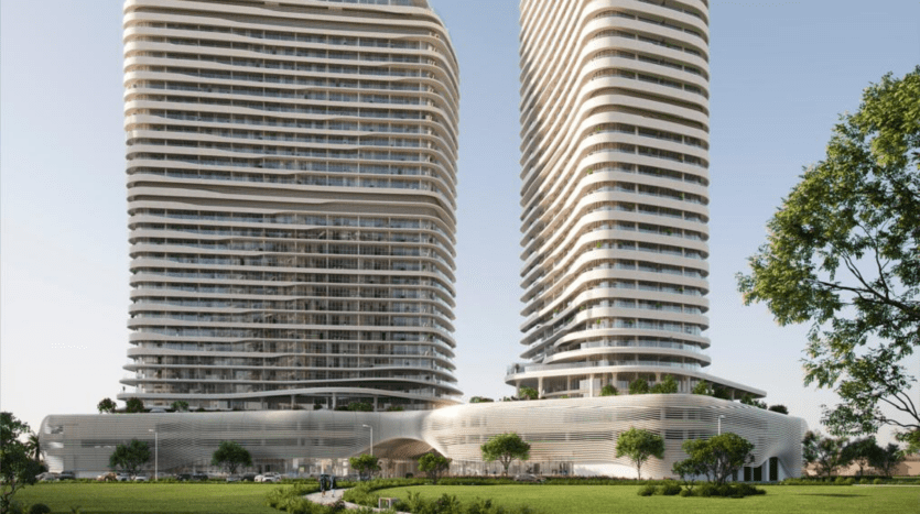 Deux gratte-ciels modernes aux façades en verre appartenant à des sociétés SaaS se dressent sous un ciel bleu clair. La base présente un design ondulé en forme de ruban entouré de pelouses vertes et de petits arbres au premier plan.
