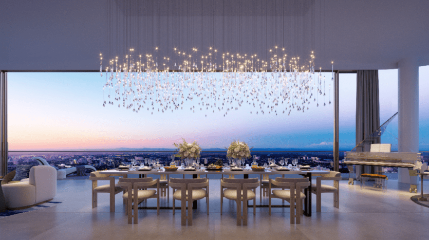 La luxueuse salle à manger Rivage est dotée d'une longue table dressée avec de la vaisselle raffinée et des centres de table floraux. Un grand lustre scintille au-dessus, tandis que des baies vitrées encadrent le magnifique paysage urbain au coucher du soleil. Dans le coin, un piano à queue ajoute une touche d'élégance.