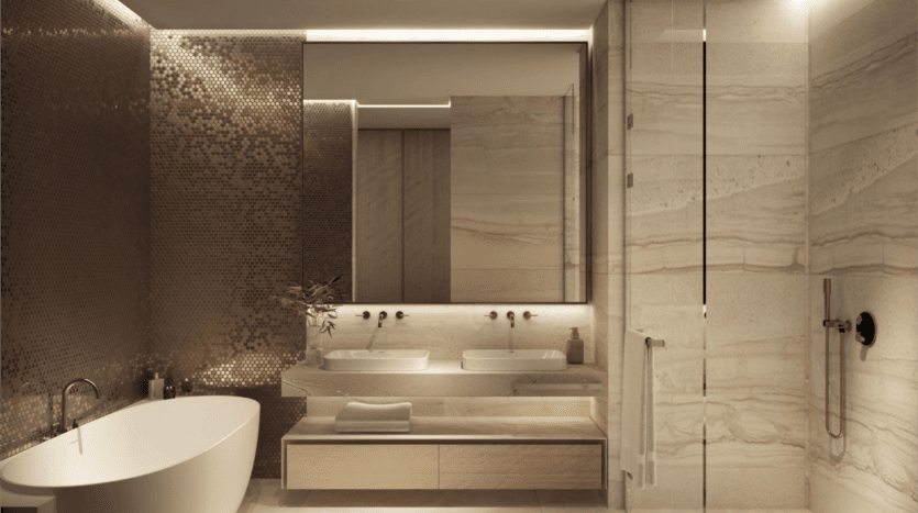 Une salle de bains moderne dans des propriétés SaaS luxueuses comprend une baignoire blanche autoportante, un meuble-lavabo double avec miroirs et une douche vitrée. Les murs présentent un design texturé aux tons cuivrés complété par un éclairage d'ambiance doux, tandis qu'une petite plante ajoute une touche de verdure.
