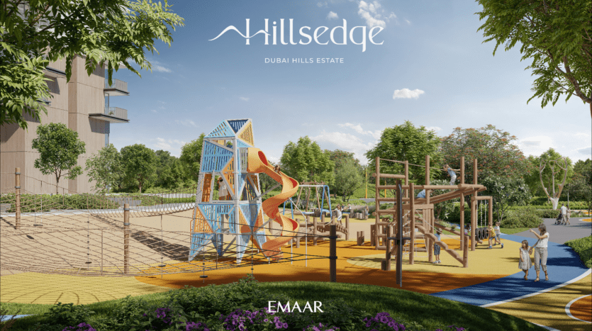 À Hillsedge, dans le quartier de Dubai Hills Estate, une aire de jeux animée comprend un toboggan coloré, des structures d'escalade et des filets de corde. Une végétation luxuriante rehausse le décor tandis qu'un bâtiment moderne se dresse fièrement en arrière-plan. Les familles se délectent de cette journée ensoleillée.