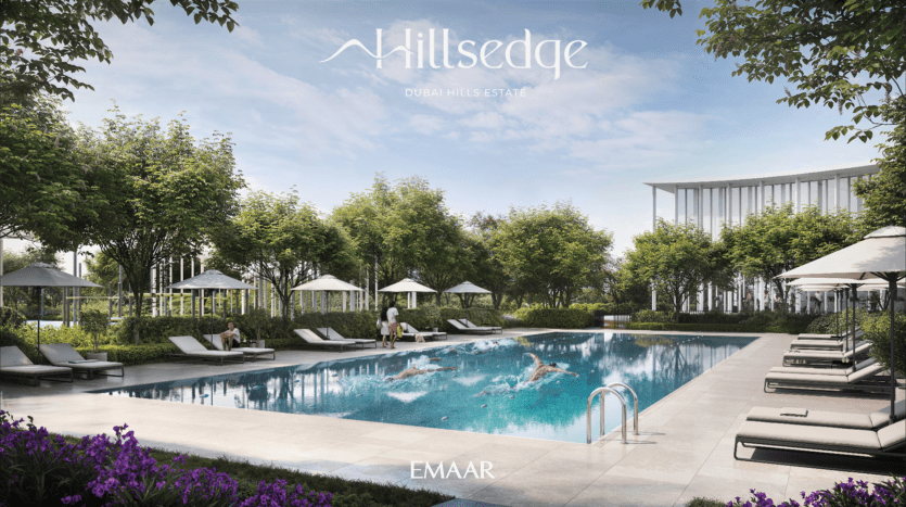 La luxueuse piscine extérieure Hillsedge du Dubai Hills Estate est entourée de chaises longues, de parasols et d'une végétation luxuriante. Deux personnes nagent pendant qu'une autre se détend sur une chaise longue. Le ciel est bleu avec des nuages épars, créant une toile de fond parfaite pour cette oasis sereine.