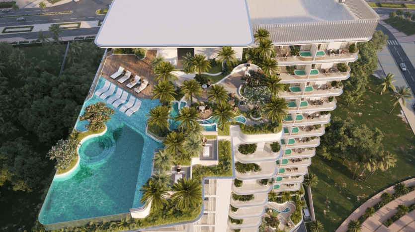 Vue aérienne d'un immeuble moderne de grande hauteur, le Cove Edition, avec une piscine sur le toit et une végétation luxuriante. Le toit comprend des chaises longues, des palmiers et plusieurs niveaux de terrasse, donnant sur une rue bordée d'arbres. L'architecture est élégante et contemporaine dans ce cadre exclusif Edition 4.