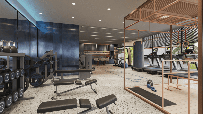 Un intérieur de salle de sport moderne avec des supports de poids, des bancs, des tapis de course, des vélos d'exercice et un espace de boxe. De grandes fenêtres laissent entrer la lumière naturelle, illuminant le design spacieux et minimaliste avec des tons bleus et neutres.