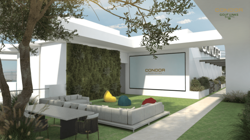 Espace salon extérieur avec mobilier moderne, dont un canapé d'angle blanc et des poufs colorés, sur une terrasse gazonnée en parfaite harmonie avec la nature. Un mur végétal met en valeur l'espace, complété par un écran affichant « Condor Signature » sur un mur blanc. Les arbres et les plantes à proximité créent une ambiance de golf.