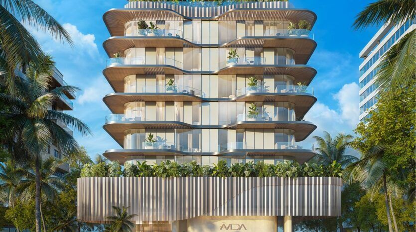 Immeuble moderne de plusieurs étages avec balcons incurvés et garde-corps en verre, entouré de palmiers. Avida Residences Dubai Islands présente de la verdure sur chaque balcon et un design épuré et contemporain sur fond de ciel bleu vif.
