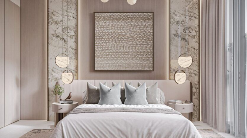 Chambre à coucher moderne avec un grand lit, une literie neutre, quatre oreillers gris, des accents muraux en marbre, des lampes suspendues rondes de chaque côté, des tables d'appoint et une grande œuvre d'art abstraite au-dessus de la tête de lit. Des rideaux encadrent une fenêtre sur la droite.