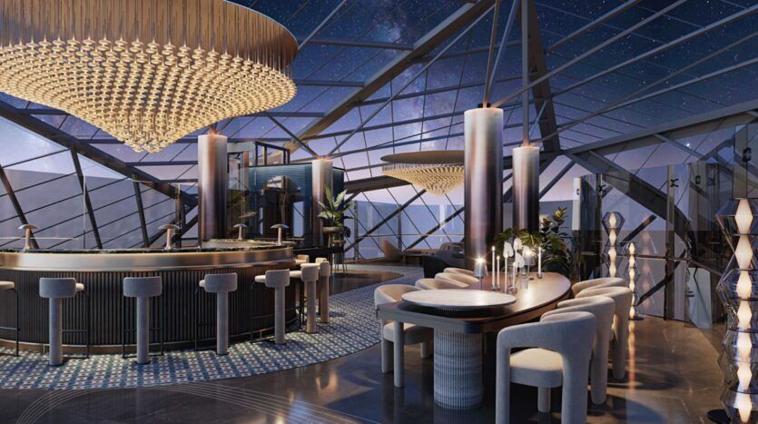 Ce salon moderne et élégant situé au Portside Square Mina Rashid est doté de murs et d'un plafond en verre allant du sol au plafond et offrant une vue sur la nuit étoilée. Des sièges en peluche, un bar circulaire, de grands lustres et un décor géométrique créent une ambiance luxueuse.