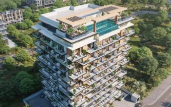 Vue aérienne d'Arlington Park 2, un immeuble résidentiel moderne de plusieurs étages avec de grands balcons, une piscine sur le toit, une végétation luxuriante et entouré d'arbres, de routes et d'immeubles voisins.