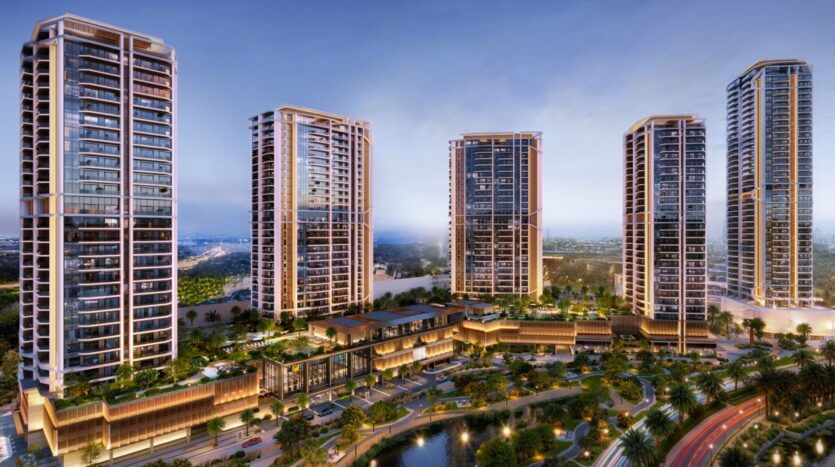 Eltiera Views is a modern urban complex consisting of five tall residential towers clad in glass, overlooking a landscaped area with palm trees, water features, and podium buildings connected at sunset.