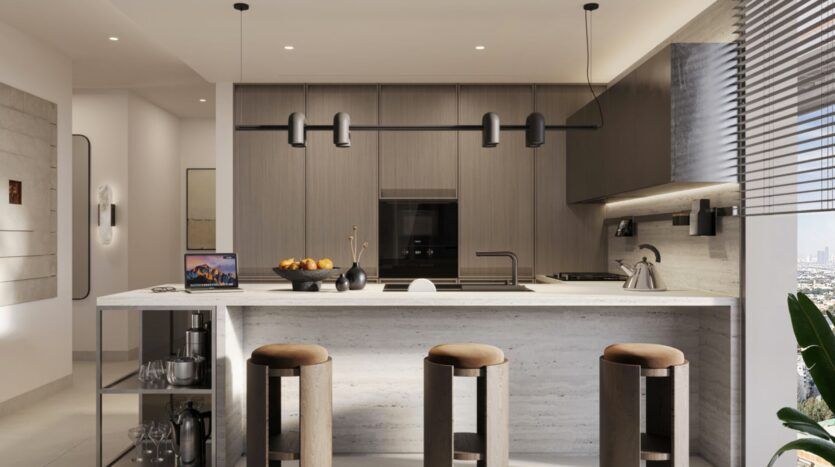 Modern kitchen with wooden cabinets, marble island, three padded bar stools, a laptop, a fruit bowl, and a kettle. Pendant lights hang above the island, while large windows offer natural views of the Eltiera and fill the space with light.